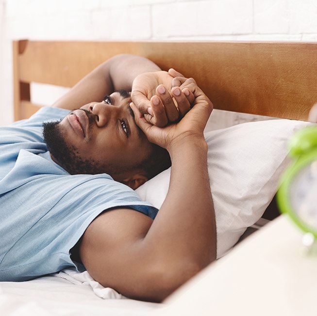 Exhausted man lying in bed